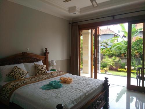 a bedroom with a bed with two stuffed animals on it at Murdhasari in Ubud