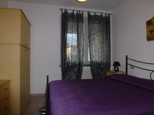 a bedroom with a purple bed and a window at Nicla 3 in Fiorino