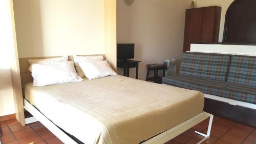 a small bedroom with a bed and a couch at Parque Campismo Porto Côvo in Porto Covo