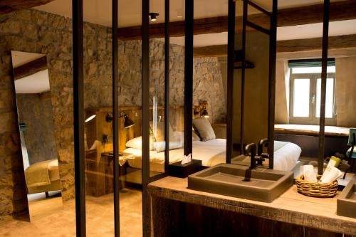 a bathroom with a sink and a bedroom with a bed at Hotel Victoria - Maison Caerdinael in Durbuy