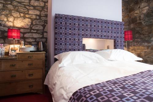 a bedroom with a bed with a blue and white at Harbourmaster Hotel in Aberaeron