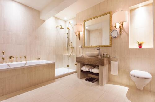 a bathroom with a sink and a tub and a toilet at Château de Bonmont in Cheserex