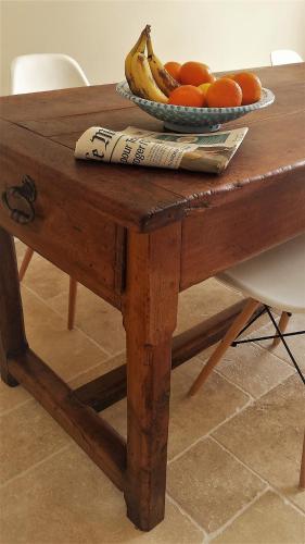 a wooden table with a plate of fruit on it at Bastide Philomen in Pérols