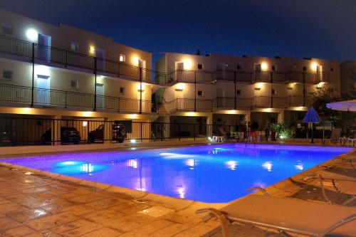 una gran piscina frente a un edificio por la noche en Peyia Pearl en Peyia
