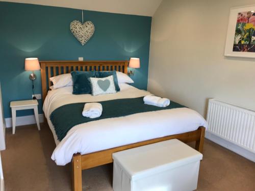 een slaapkamer met een bed met groene muren bij Crannaford Cottage in Broad Clyst