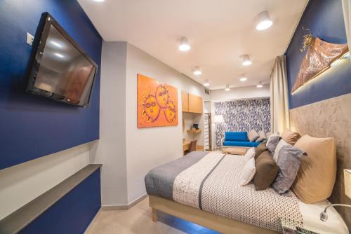 a bedroom with a bed and a tv on a wall at Airone Hotel in Naples