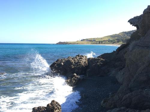 a beach with rocks and the ocean and the water at A.A Michael Apartments in Pachyammos