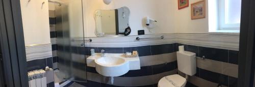 a bathroom with a sink and a toilet and a mirror at Hotel Marinella in Celle Ligure