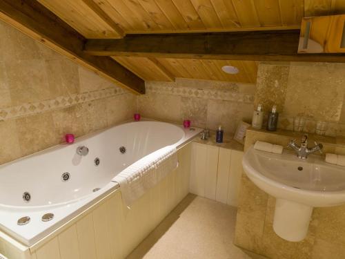a bathroom with a bath tub and a sink at The Old Town Hall in Redmire