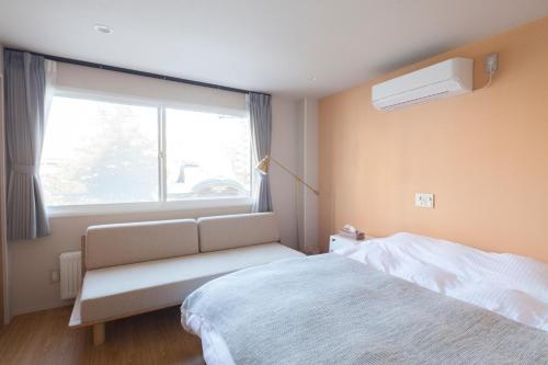 a bedroom with a bed and a window at Private house Kuranoya Sapporo in Sapporo