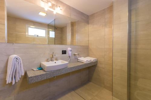 W łazience znajduje się umywalka i lustro. w obiekcie Hotel Alpre w mieście Villa Carlos Paz
