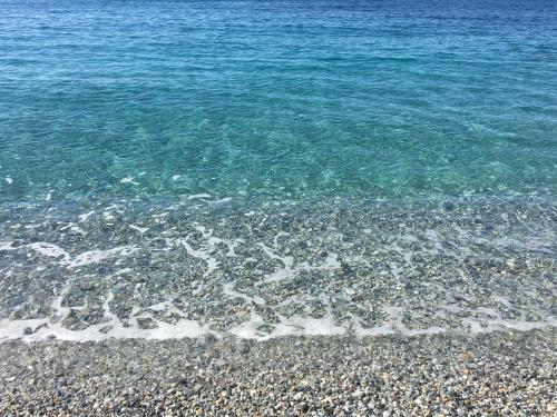 a beach with rocks and the blue water at Mareblù in Scilla