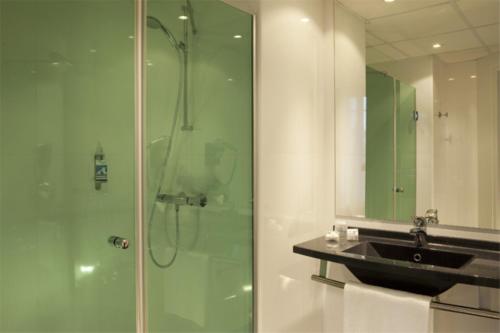 a bathroom with a shower, sink, and tub at Escale Oceania Vannes Centre in Vannes