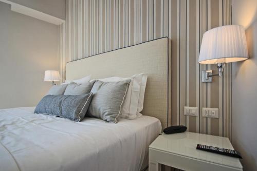 a bedroom with a bed and a table with a lamp at Hotel Plaza in Porto Azzurro