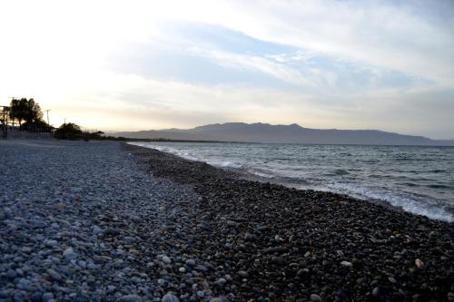 a pebble beach on the shore of the ocean at Augusta Country House in Derés