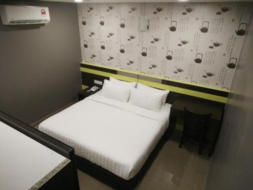 a small room with a bed and a wall with glasses at Kampar Boutique Hotel in Kampar