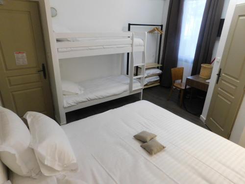 a bedroom with a white bed with a towel on it at Hôtel-Restaurant "Chez Carrière" in Aigues-Mortes