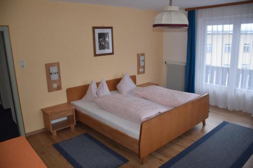 a bedroom with a bed with white sheets and pillows at Haus Valentin in Heiligenblut