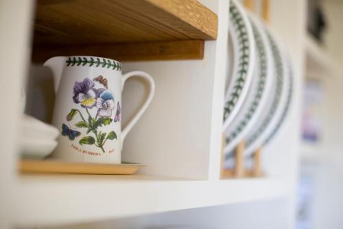 a cup and plates sitting on a shelf at The Hideaway Huts in Bardon Mill
