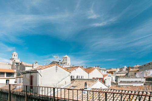 - une vue sur une ville avec des toits et un ciel nuageux dans l'établissement Maison de charme d'Arles, à Arles