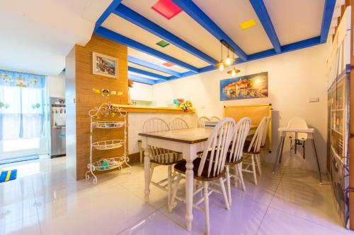 a dining room with blue ceilings and a table and chairs at Romance Greece in Luodong