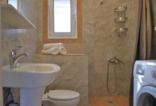 a bathroom with a sink and a toilet and a shower at Kiveri Gems Houses in Kivérion