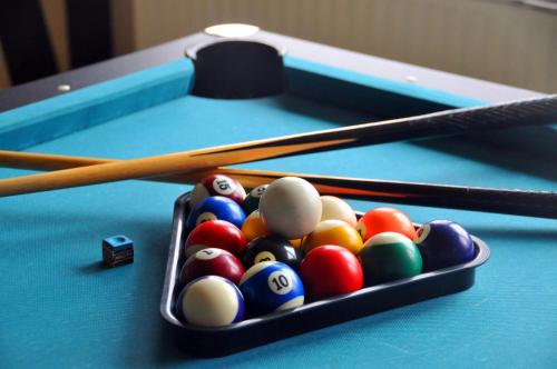 two pool balls and cue sticks on a pool table at Hotel Niedersfeld-Winterberg in Winterberg