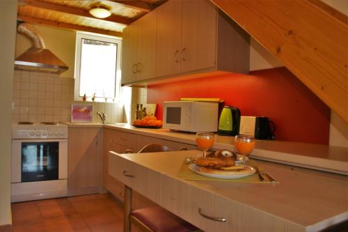 eine Küche mit einem Tisch mit einem Teller Essen und zwei Gläsern in der Unterkunft Kiveri Gems Houses in Kiveri