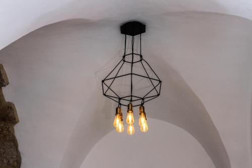 a black chandelier hanging from a ceiling at Acre Two Wells Zimmer in ‘Akko