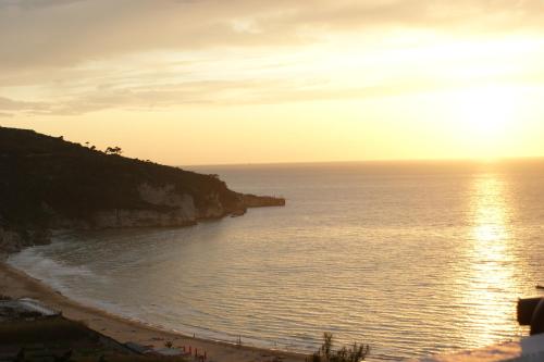 a view of a beach with the sun setting over the ocean at The Stunning B&B in Peschici