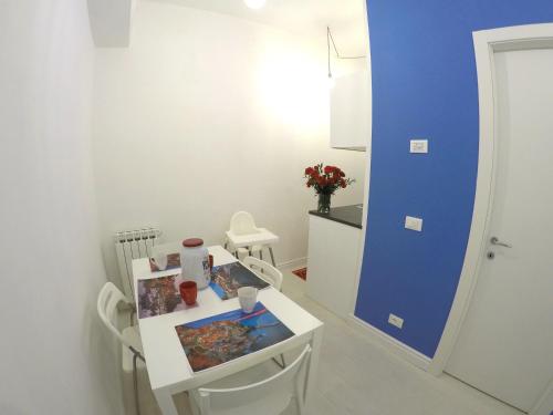 um quarto com uma mesa branca e uma parede azul em Interno5 Apartment em La Spezia