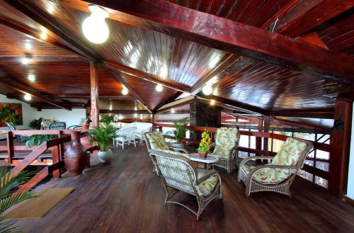 Habitación con sillas, mesas y techo de madera. en Hotel Adriattico, en Porto Seguro