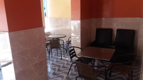 um restaurante com mesas e cadeiras num quarto em Hotel Gazcue em Santo Domingo