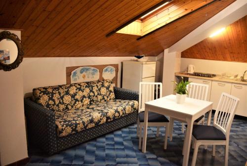 - un salon avec un canapé et une table dans l'établissement Mansarda Natalie, à Levanto
