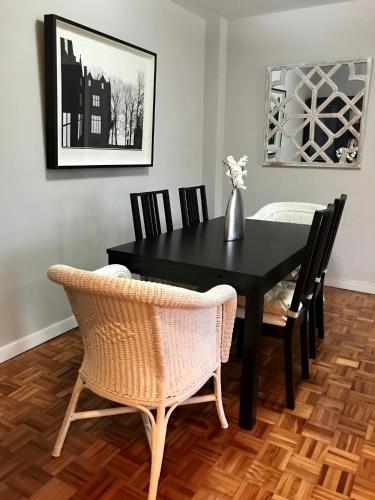 a black dining room table with chairs and a vase on it at Lauramer Apartamento Bakio in Bakio