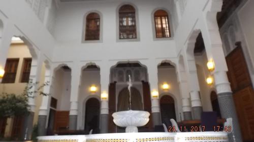 un grand bâtiment blanc avec un vase blanc au centre dans l'établissement Riad jasmins & Spa, à Fès