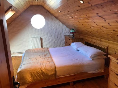 ein Schlafzimmer mit einem Bett im hölzernen Dachgeschoss in der Unterkunft Ned's Cottage in Kincasslagh