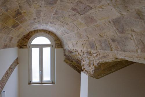 ventana en una habitación con techo de piedra en Marie Claire Apartments & Spa, en Vasto