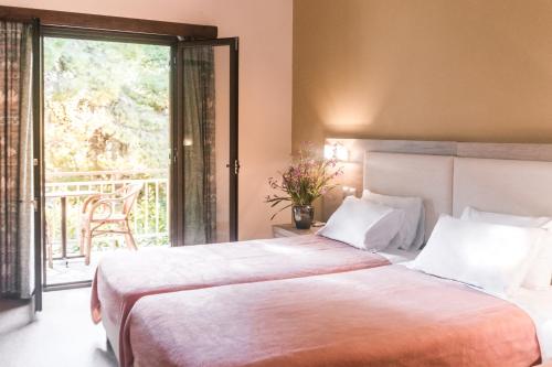 a bedroom with a large bed and a balcony at The Delfini Hotel in Agia Marina Aegina