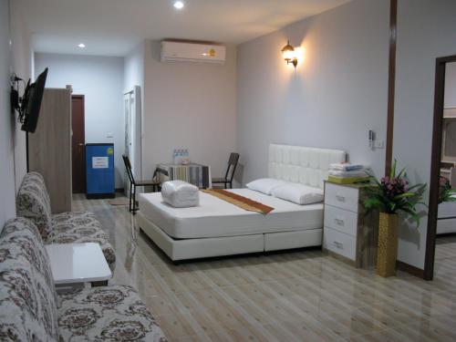 a living room with a couch and a bed at Tamruethai House - ตามฤทัยเฮาส์ in Chiang Mai