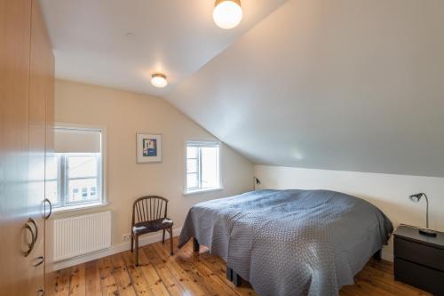 a bedroom with a bed and a chair in it at Lækjargata apartment in Akureyri
