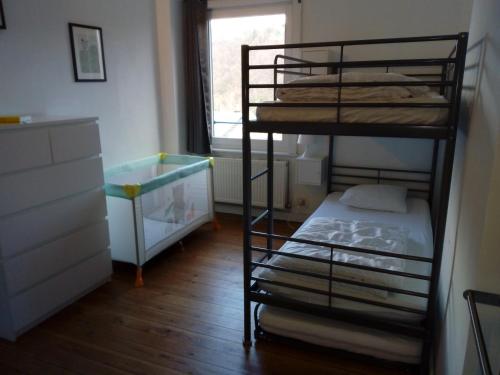 a bedroom with two bunk beds and a window at La petite maison in Aywaille