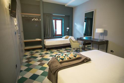 BnB Villa Sant'Angelo في جينوسا مارينا: غرفة فندق بسرير ومكتب وغرفة نوم
