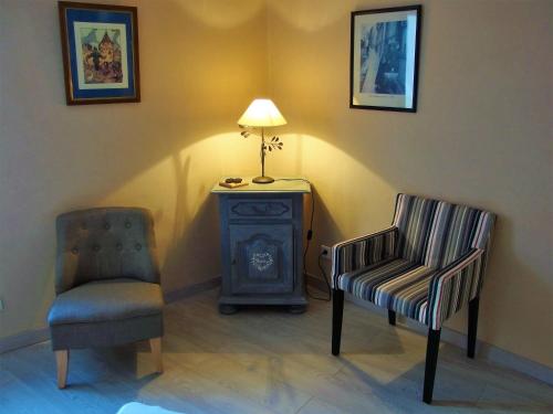 two chairs and a lamp in a room with a stove at La maison Céline in Bergheim