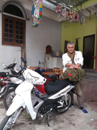 a man sitting on the seat of a motorcycle at Ngan Ha Homestay in Ha Giang