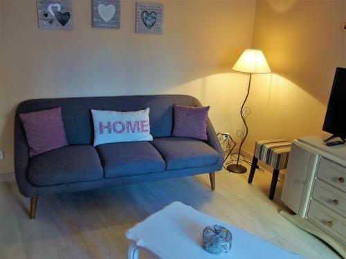 a living room with a blue couch with a home pillow at La maison Céline in Bergheim