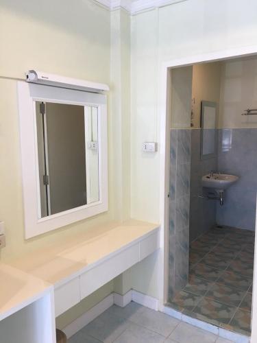 a bathroom with a sink and a shower and a mirror at Thai Orchid Guest House in Jomtien Beach