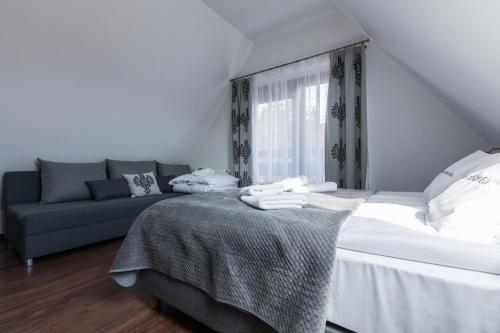 a bedroom with a bed and a couch at Willa Baciarka-basen, sauny i jacuzzi in Kościelisko