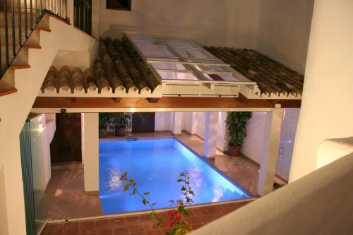 a swimming pool with a tub and a table in the middle of it at La Posada del Angel in Ojén
