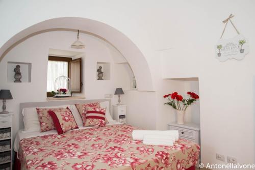 a bedroom with a large bed with red pillows at Giardino Segreto in Putignano